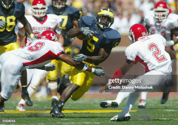 David Underwood of the Michigan Wolverines runs the ball against Will Gulley and Roland Cola of the Houston Cougars on September 6, 2003 in Ann...