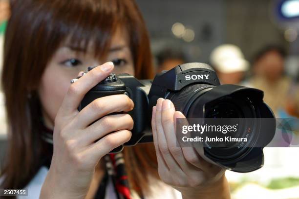 Woman demonstrates Sony's newly introduced eight million-pixel digital camera the Cyber-Shot digital camera DSC-F828 during Asia's biggest digital...