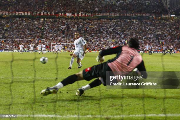 Andriy Shevchenko of Milan scores the winning goal from the penalty shoot out against Juventus FC goalkeeper Gianluigi Buffon during the UEFA...