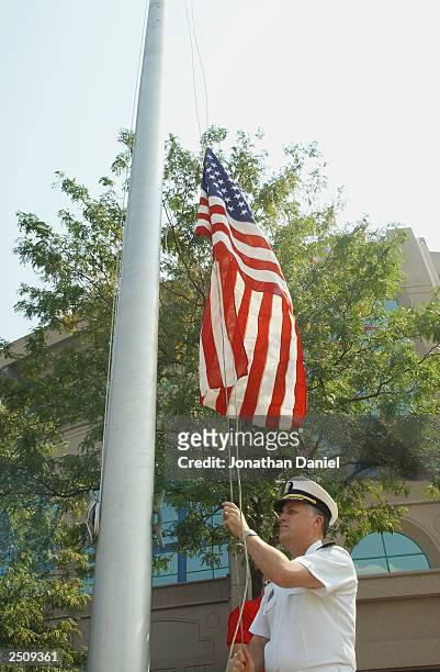 Navy Captain David Johnson, who works at the Pentagon and was there the morning of the terrorist attacks on September 11 raises a flag that flew over...