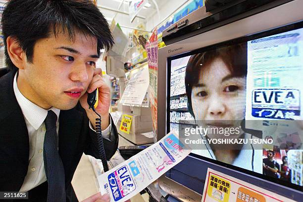 This photo taken 08 September 2003 shows a pharmacist in the video monitor showing antipyretics and gives suggestion to a customer through the...