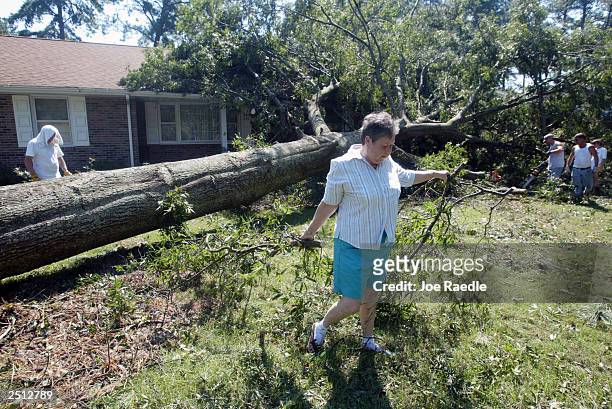 Shirley Miller clears up her front yard after a tree fell on her home when Hurricane Isabel passed through September 19, 2003 in Poquoson, Virginia....