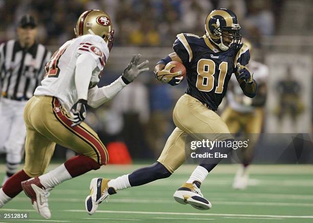 Torry Holt of the St. Louis Rams runs the ball across midfield against the San Francisco 49ers on September 14, 2003 at the Edward Jones Dome in St....