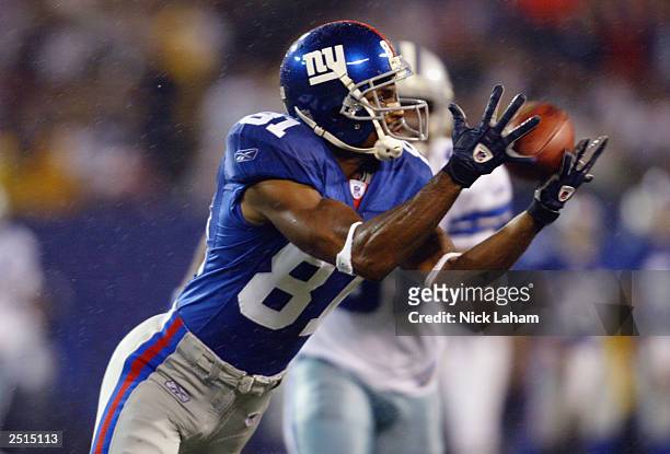 Amani Toomer of the New York Giants catches a pass against the Dallas Cowboys on September 15, 2003 at Giant Stadium in East Rutherford, New Jersey....