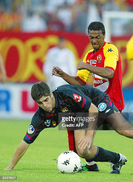 Lyon's defender Juninho Pernambucano fights for the ball with Le Mans forward James Fanchone , 21 September 2003 at the Bollee Stadium in Le Mans...