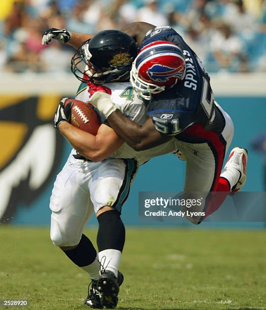 Marc Edwards of the Jacksonville Jaguars tries to avoid the tackle of Takeo Spikes of the Buffalo Bills on September 14, 2002 at Alltel Stadium in...