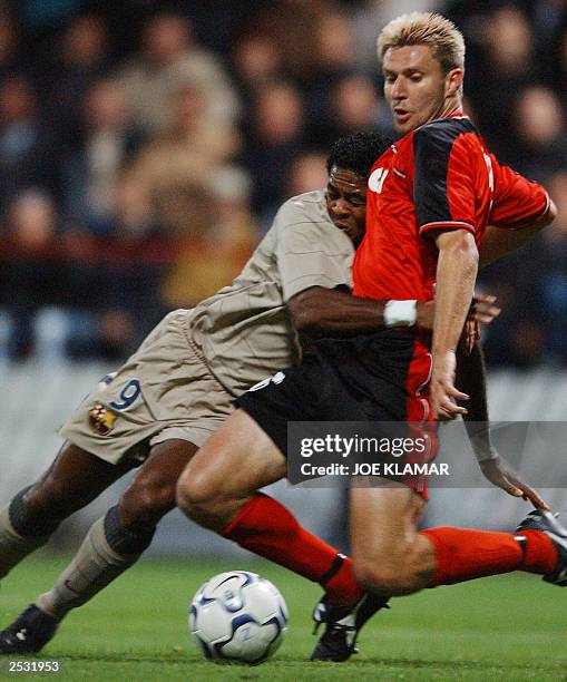 Peter Cvirik of Matador Puchov is tackled by Dutch Patrick Kluivert of FC Barcelona during the UEFA match between Matador Puchov and FC Barcelona in...