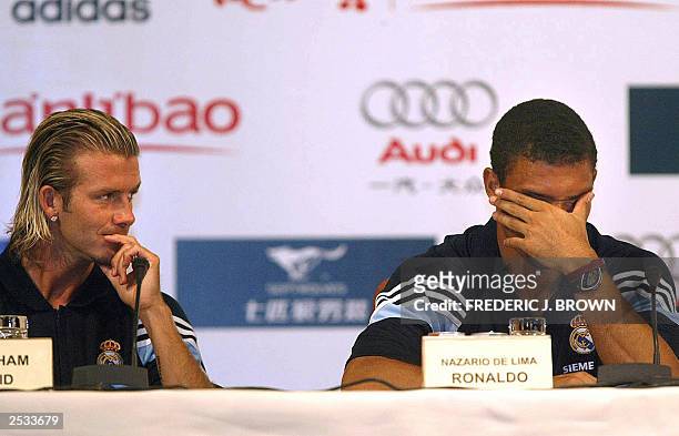 Spanish giants Real Madrid's Brazilian star Ronaldo shows fatigue as England's David Beckham looks on, 01 August 2003, during a press conference in...