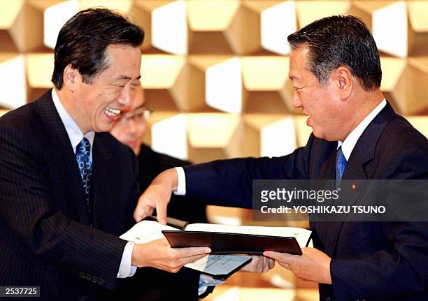 Japan's largest opposition Democratic Party of Japan leader Naoto Kan and the smaller opposition Liberal Party leader Ichiro Ozawa exchange the...