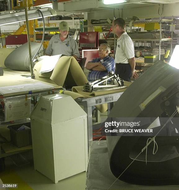 Technicians check the specifications on one of space shuttle Atlantis' wing leading edge reinforced carbon carbon section 26 September 2003, in OPF-1...