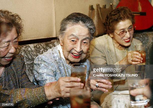 Photo taken 16 May 2003 shows Hideko Arima 101-year-old bar proprietress drinking during her 101st birthday party at her tiny bar Gilbey-A at Ginza...