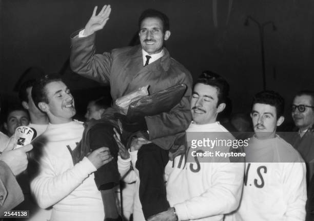 French runner Alain Mimoun is chaired by fellow athletes on his arrival at Orly from Australia, where he won the gold medal for the marathon at the...