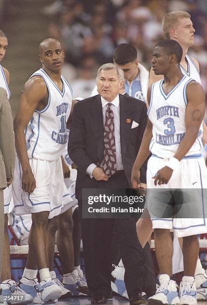Coach Dean Smith speaks with guards Vince Carter and Shammond Williams of the North Carolina Tarheels during a NCAA Final Four game against the...