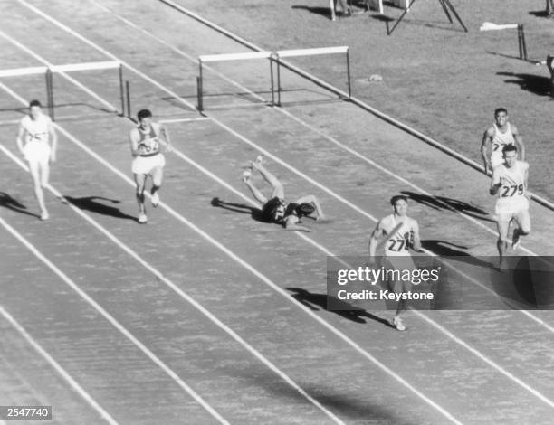 South African athlete Gerhardus Potgieter trips up at the last hurdle during the final of the 400 metres hurdles during the Olympic Games, Melbourne,...