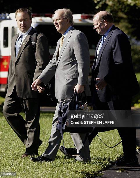 White House Press Secretary Scott McCelland walks with advisor Karl Rove and Deputy Chief of Staff Joe Hagin as they follow US President George W....