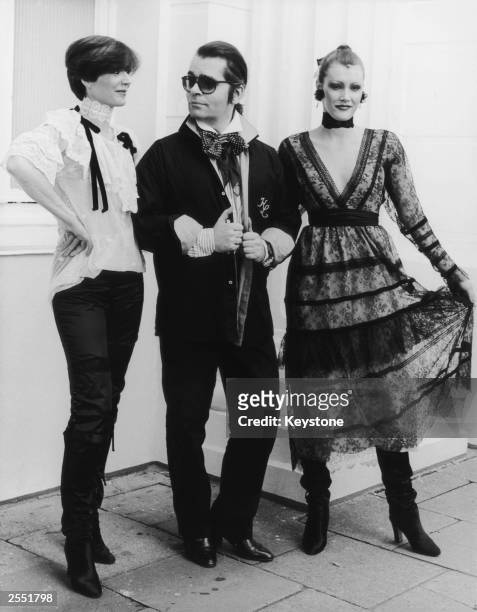 German fashion designer Karl Lagerfeld with two models, circa 1984.