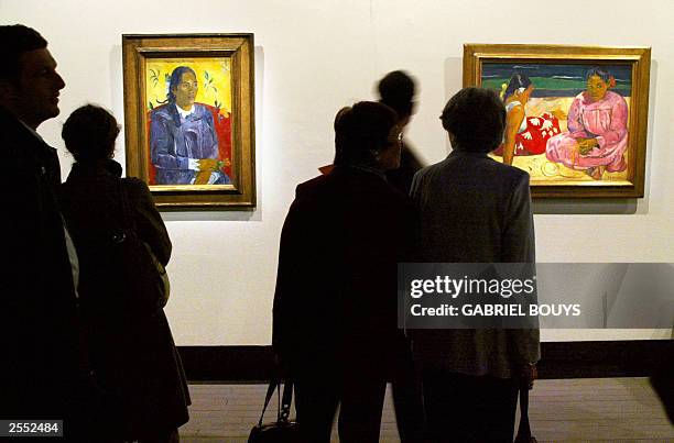 People look at "La femme a la fleur" and "Femmes de Tahiti sur la plage" , oil paintings dated 1891 by French Paul Gauguin as they visit the...