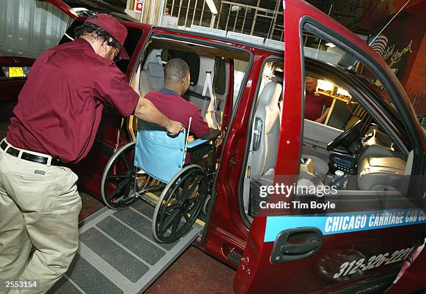 Chicago Carriage Cab taxi cab drivers William Bundy and Rafiu Ayantoye demonstrate the proper technique for transporting a disabled wheelchair client...