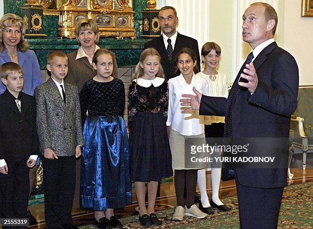 Russian President Vladimir Putin gestures as he speakes with children during their meeting at Moscow's Kremlin 02 October 2003. The President met...