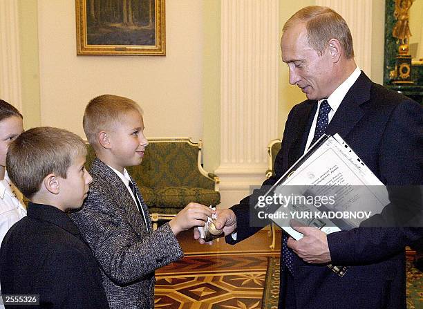 Russian President Vladimir Putin receives a present from Latvian schoolboy Yroslav Karpelyuk during their meeting in Moscow's Kremlin, 02 October...