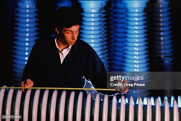 factory worker measuring up electricity pylon insulator - insulator stock pictures, royalty-free photos & images