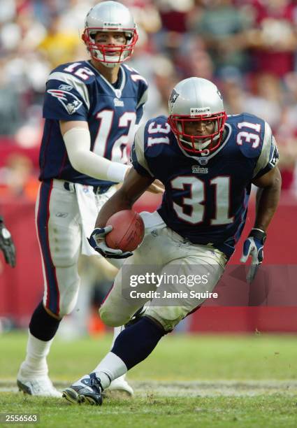 Larry Centers of the New England Patriots runs upfield as quarterback Tom Brady watches against the Washington Redskins on September 28, 2003 at...