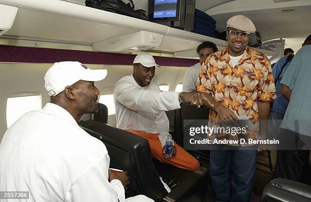 Karl Maolne, Horace Grant, Rick Fox and Derek Fisher of the Los Angeles Lakers on the plane before leaving for training camp October 2, 2003 in...