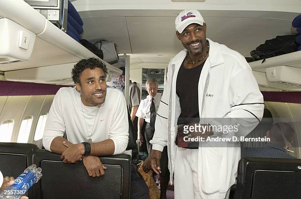 Karl Malone and Rick Fox of the Los Angeles Lakers joke around on the plane before leaving for training camp October 2, 2003 in Honolulu, Hawaii....