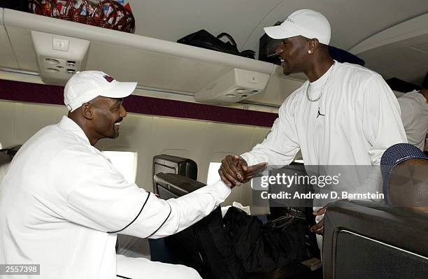 Karl Malone and Gary Payton of the Los Angeles Lakers greet each other on the plane befor leaving for training camp October 2, 2003 in Honolulu,...