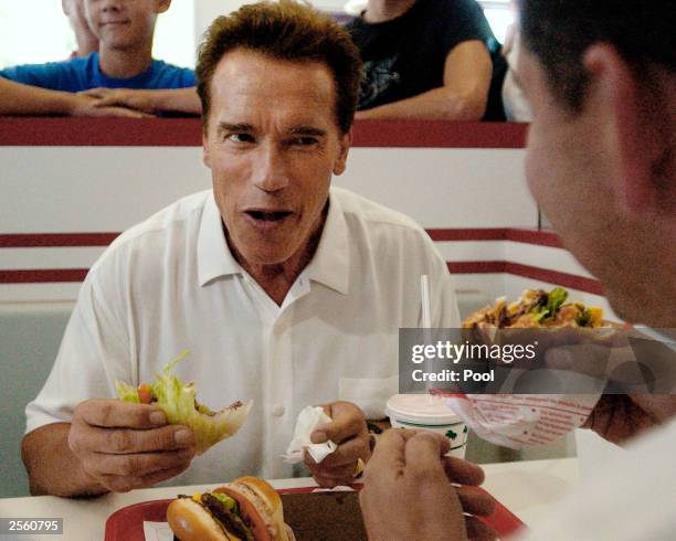 California gubernatorial candidate Arnold Schwarzenegger eats at an "IN & Out" restaurant with with California Assemblyman Abe Maldonado during a...