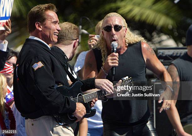 Republican gubernatorial candidate Arnold Schwarzenegger plays air guitar as Dee Snider sings the Twisted Sister song "We're Not Gonna Take It"...