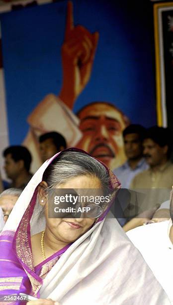 The leader of Bangladesh's main opposition party the Awami League Sheikh Hasina Wajed writes a speech in front of a portrait of her father Sheikh...