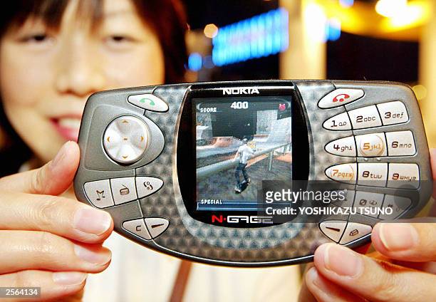 Japan's software house G-mode employee Izumi Hashimoto displays the Finish mobile communication giant Nokia's latest portable video game machine...