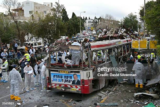 Israeli rescue workers and police search for evidence and victims at the scene of a Palestinian suicide bombing on an Israeli bus March 5, 2003 in...