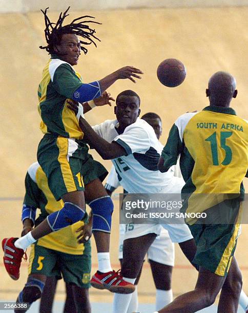South Africa 's Pekile Victor jumps to collect the ball as Senegalese defenders rush in as part of the handball match opposing South Africa vs...