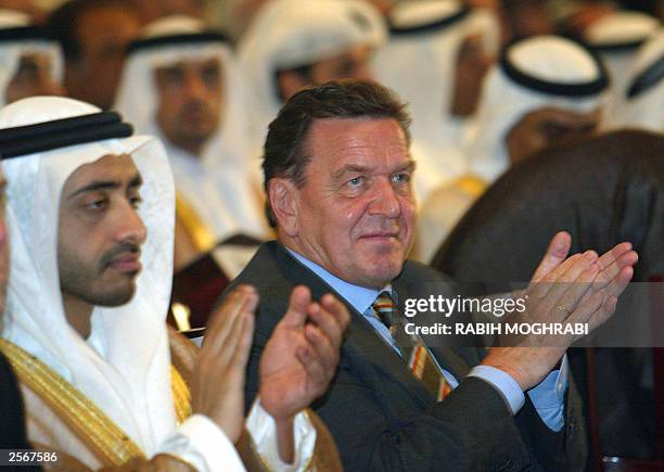 German Chancellor Gerhard Schroeder claps as he sits with shiekh Abdullah Bin Zayed al-Nahyan, minister of information during the opening session of...