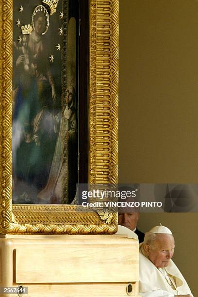 Pope John Paul II is taken past a painting of "Madonna del Rosario" as he makes his way to pray for world peace at the shrine of Virgin Mary in...