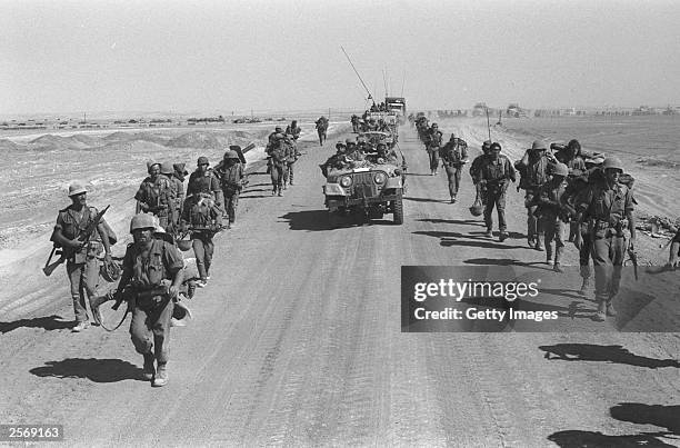 Israeli paratroopers march October 25, 1973 along the Suez-Cairo road on the western bank of the Suez Canal during the Yom Kippur War. Current...