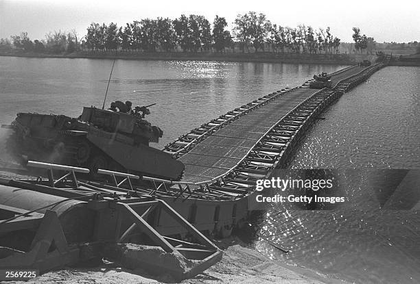 Israeli tanks cross a bridge built by Israeli troops over the Suez Canal October 25, 1973 in the Sinai Desert during the Yom Kippur War. Israeli...