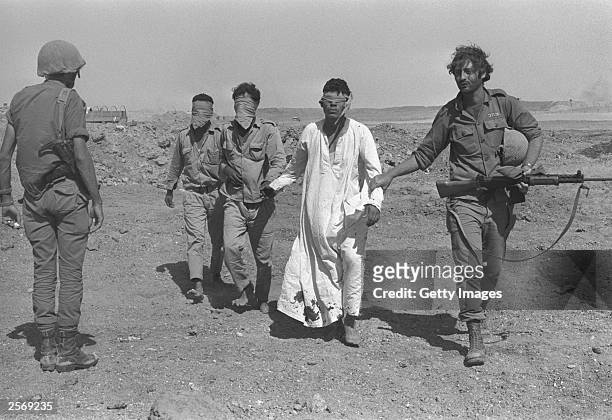 An Israeli army soldier leads blindfolded Egyptian prisoners-of-war October 21, 1973 in the Sinai Desert during the Yom Kippur War. Israeli Prime...