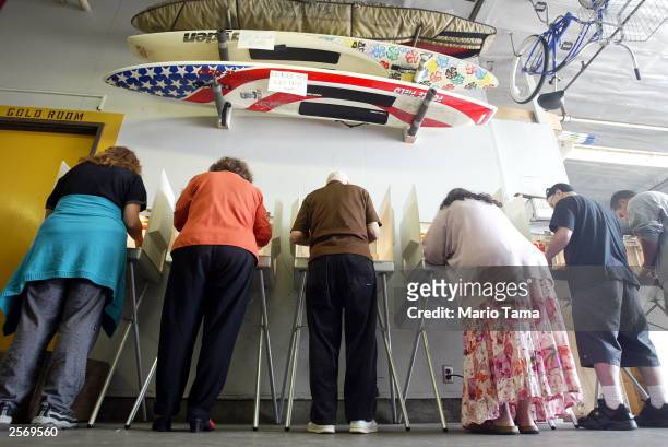 Voters mark their ballots beneath surfboards in a Venice Beach lifeguard station during the California gubernatorial recall election October 7, 2003...