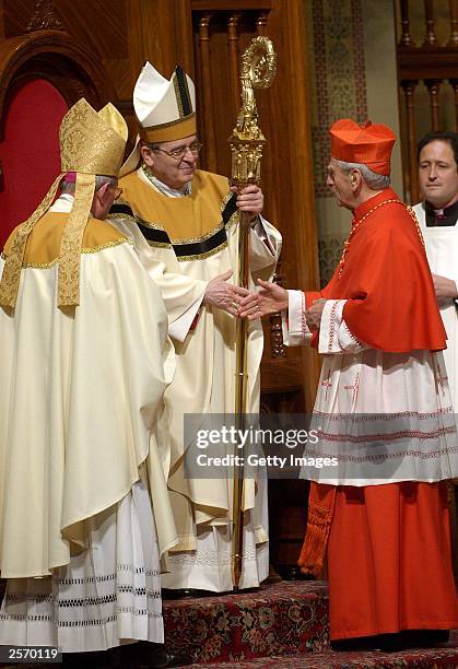 Newly installed Archbishop of Philadelphia Justin Rigali accepts the crozier from Papal Nuncio Gabriel Montalvo , and is congratulated by Anthony...