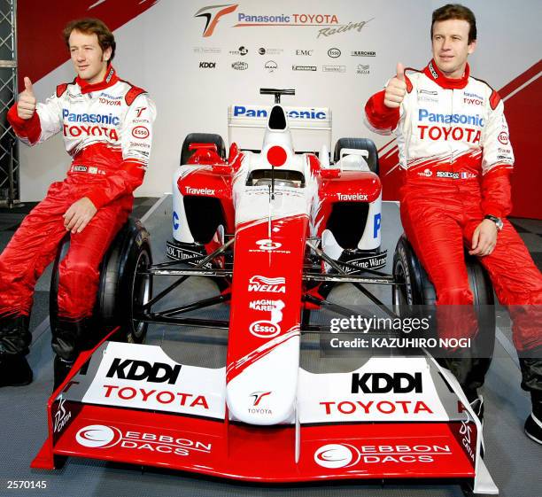 Formula One Panasonic Toyota racing team drivers Olivier Panis of France and Cristiano de Matta of Brazil give a thumbs-up on a racing car during a...