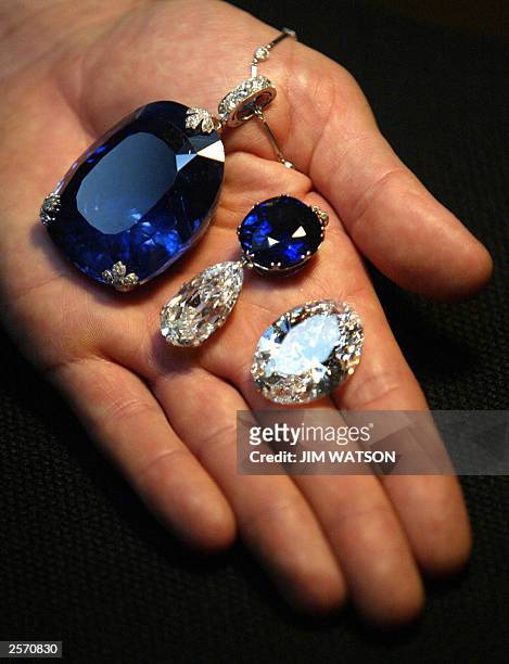 Man holds a 478 carat sapphire which was previously owned by Queen Marie of Romania, Belle Epoque necklace with cushion-shaped sapphire weighing...