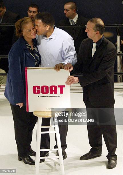 Boxing legend Muhammad Ali receives a kiss from his wife Lonnie, as German publisher Benedikt Taschen looks on during a presentation of Ali's book...