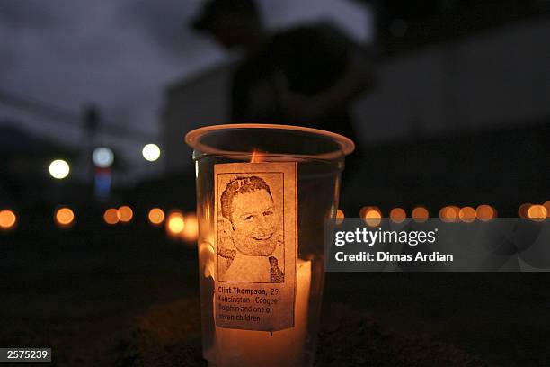 Candle with a photograph of a Bali bombing victim is seen on October 9, 2003 at Kuta Beach in Bali, Indonesia. October 12, 2003 marks the first year...