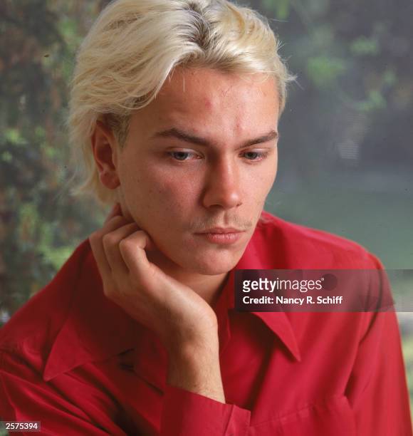 Studio headshot portrait of American actor River Phoenix , 1991. He has bleached blonde hair and a mustache.