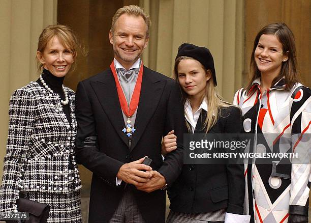 Gordon Sumner "Sting" poses with his wife Trudi Styler, and daughters Coco and Kate holding his CBE at Buckingham Palace in London 09 October 2003,...