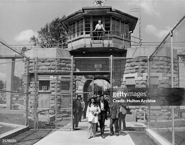 American country singer Johnny Cash and his wife June Carter Cash leave the front gate of Kansas State Prison, circa 1968.