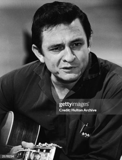 American country singer Johnny Cash plays acoustic guitar in a still form his television series, 'The Johnny Cash Show,' circa 1969.